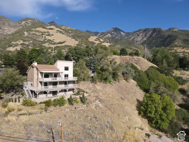 Multi-level residence featuring a tiered deck, brick chimney, and a light-colored stucco exterior