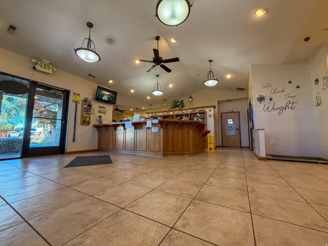 Tiled flooring, vaulted ceilings with exposed beams, wood-finish reception desk, recessed lighting, and ceiling fans
