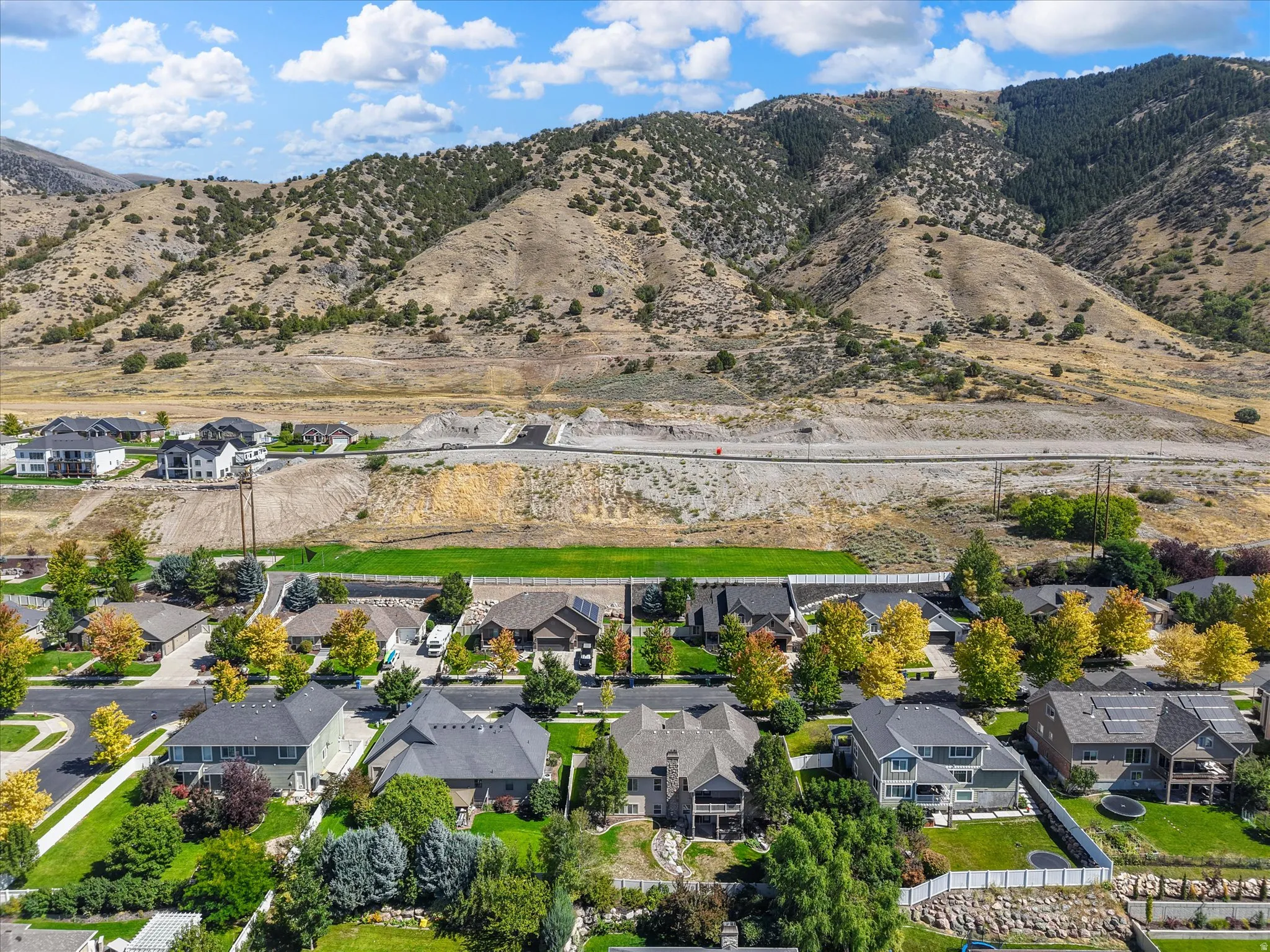 Mountainous backdrop with residential properties and green landscaping
