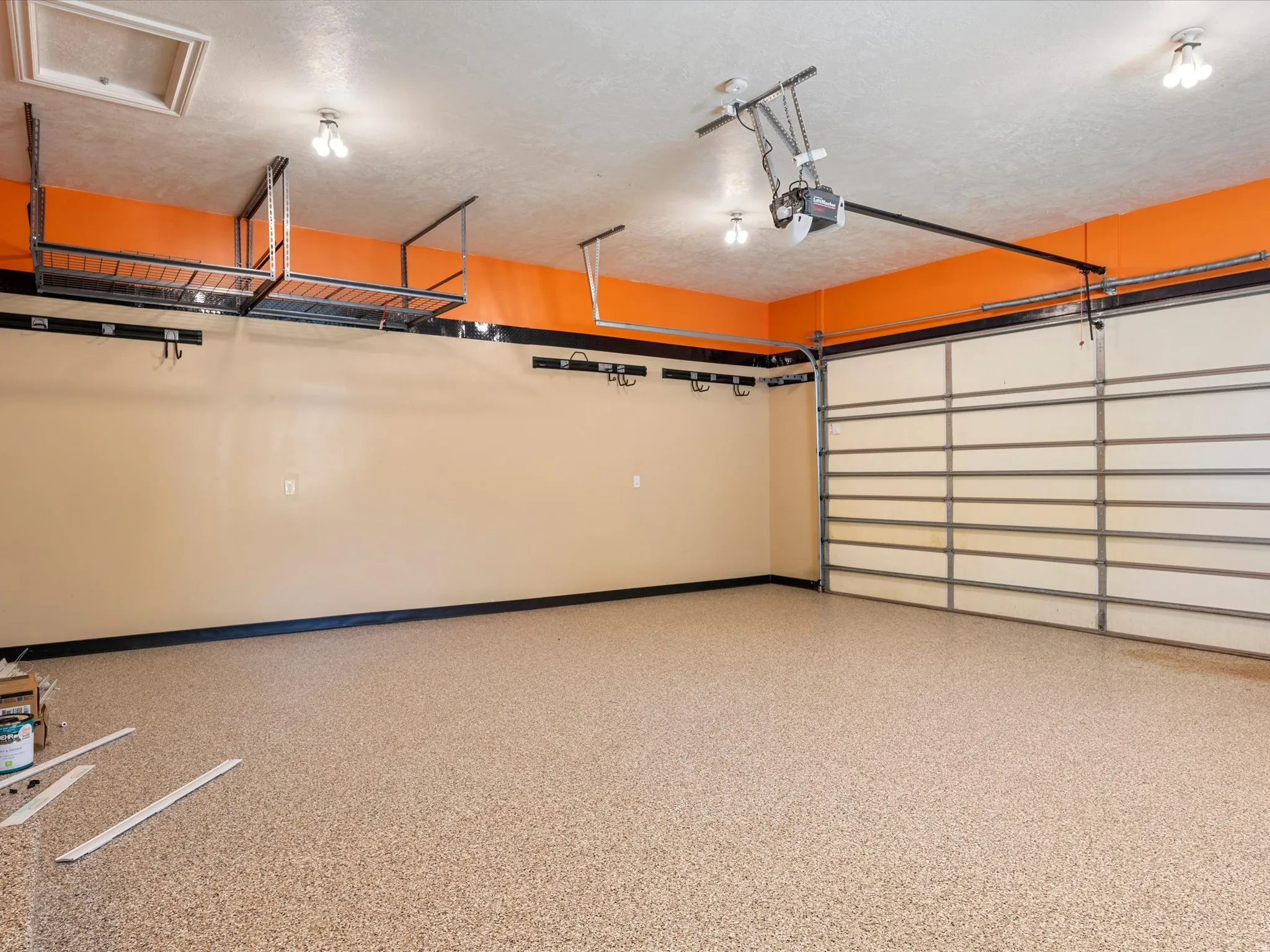 Garage space featuring an epoxy-coated floor, overhead storage racks, and an automatic garage door opener