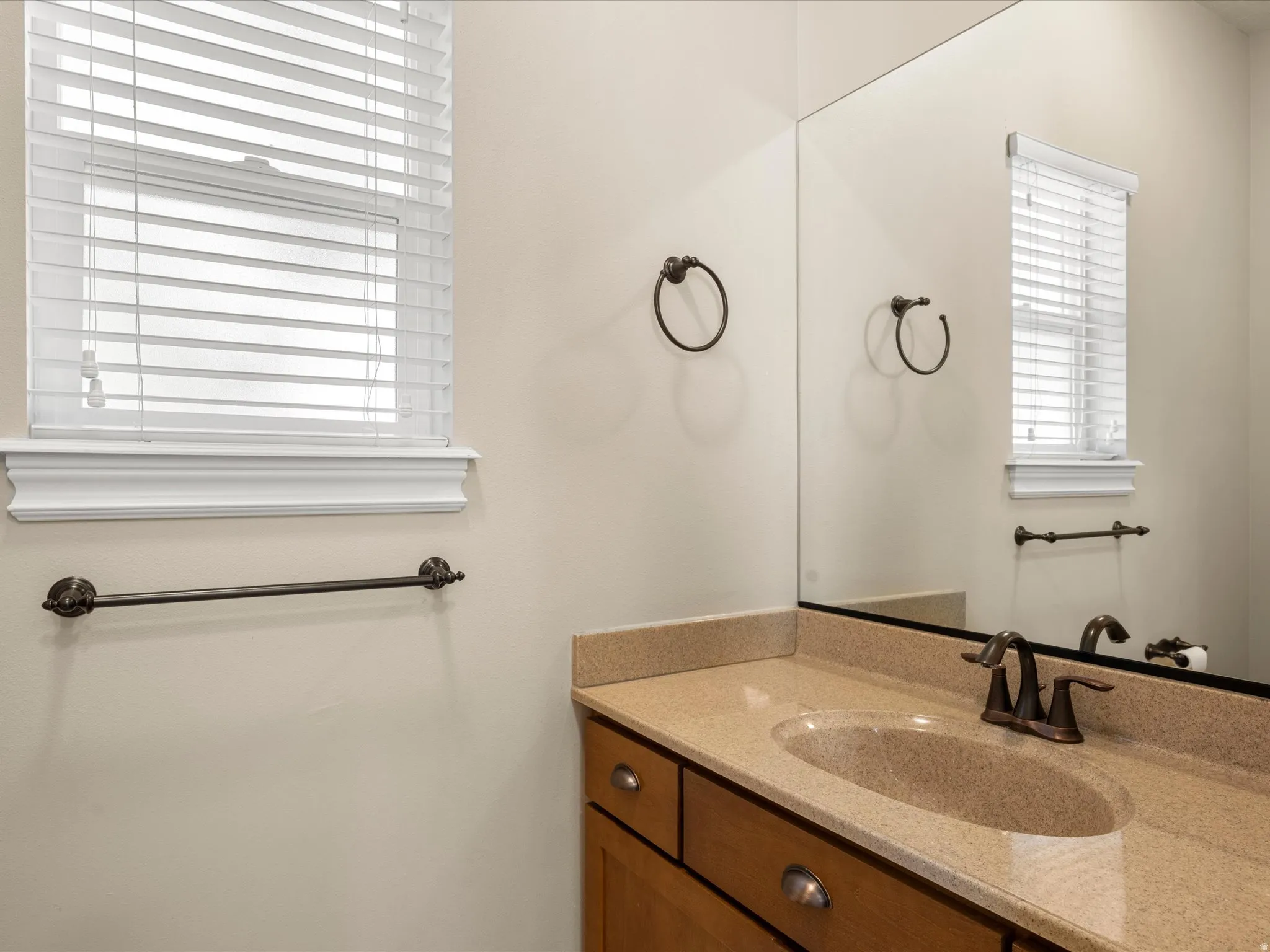 Integrated vanity with an oval sink, counter space, and a wall-mounted mirror