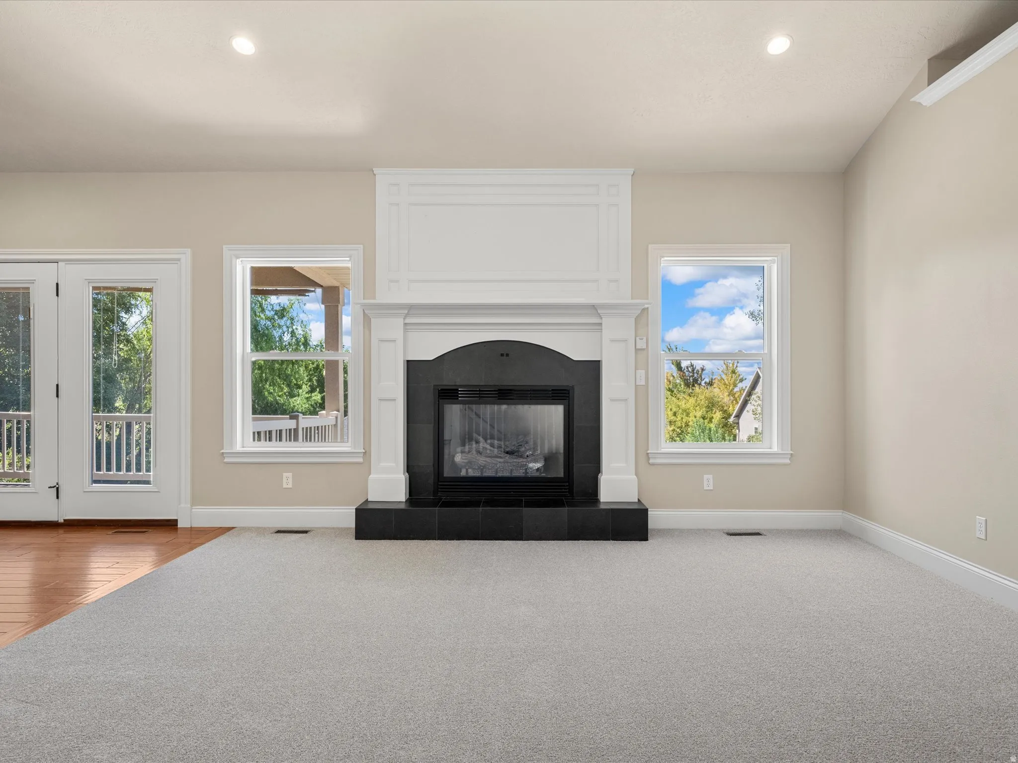 Fireplace with a black hearth, white mantel, and surrounding trim