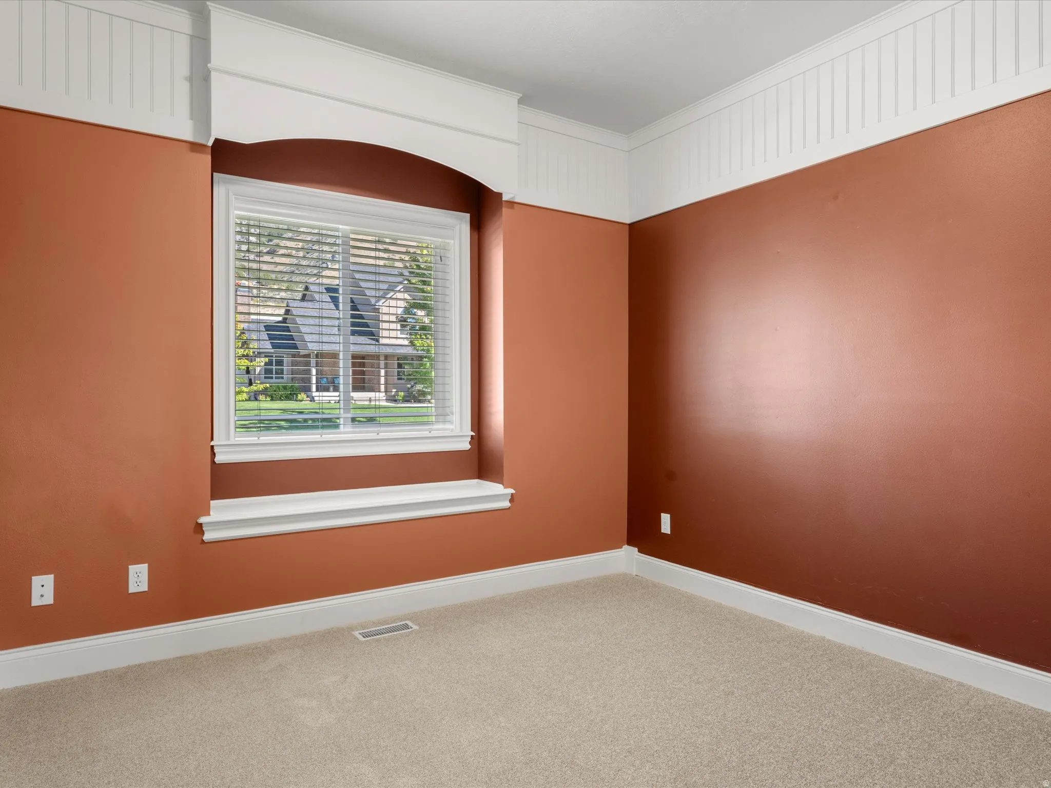 Recessed window with white trim and sill, accompanied by a decorative arched header