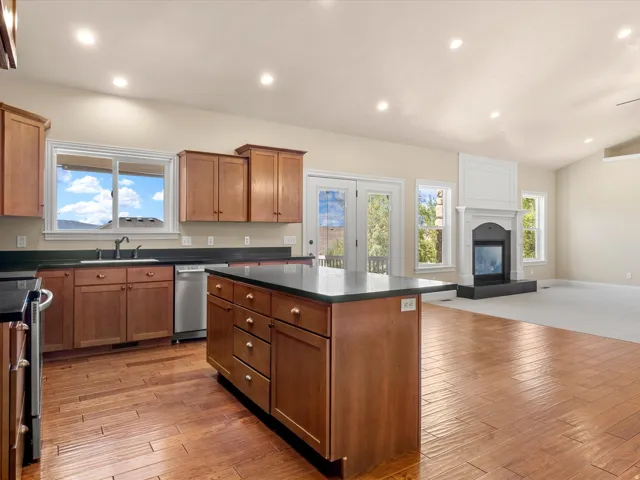 Open-concept kitchen featuring wood-finish flooring, recessed lighting, a central island, and wood cabinetry