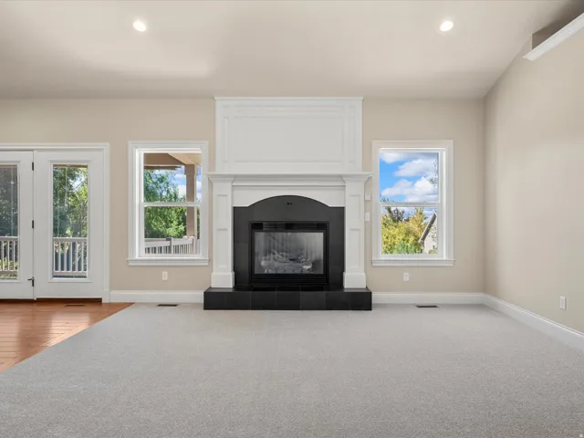 Fireplace with a black hearth, white mantel, and surrounding trim