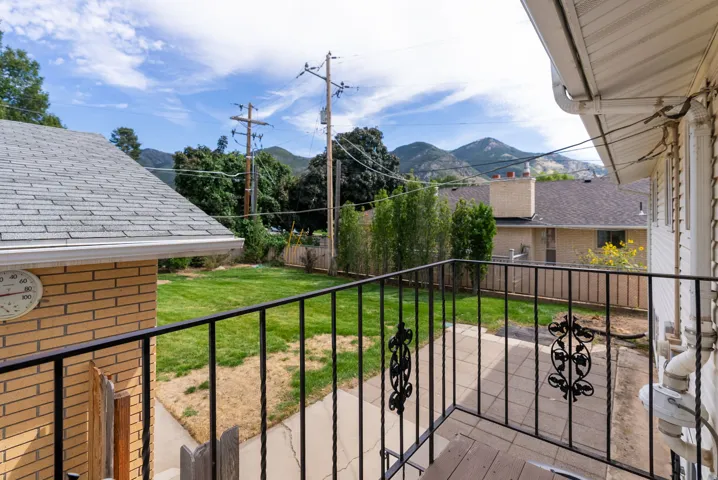 Expansive grassy yard with mountain backdrop, surrounded by privacy fencing