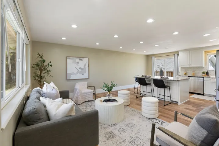 Open-concept living space featuring recessed lighting, wood-finish flooring, and a kitchen island with seating