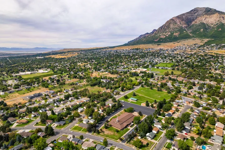 Expansive neighborhood with mature trees, established residential properties, and paved streets