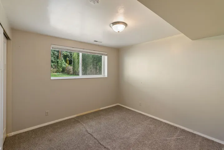 Recessed window with natural light, neutral wall tones, semi-flush mount ceiling light, and wall-to-wall carpeting