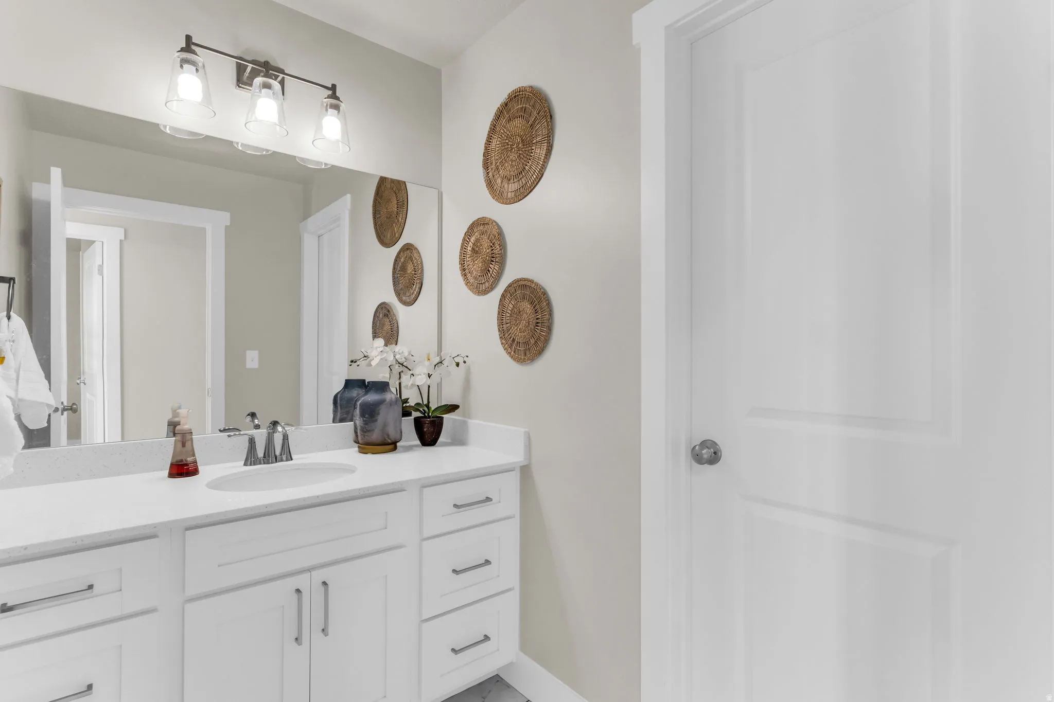 White vanity with integrated sink, chrome faucet, and integrated lighting