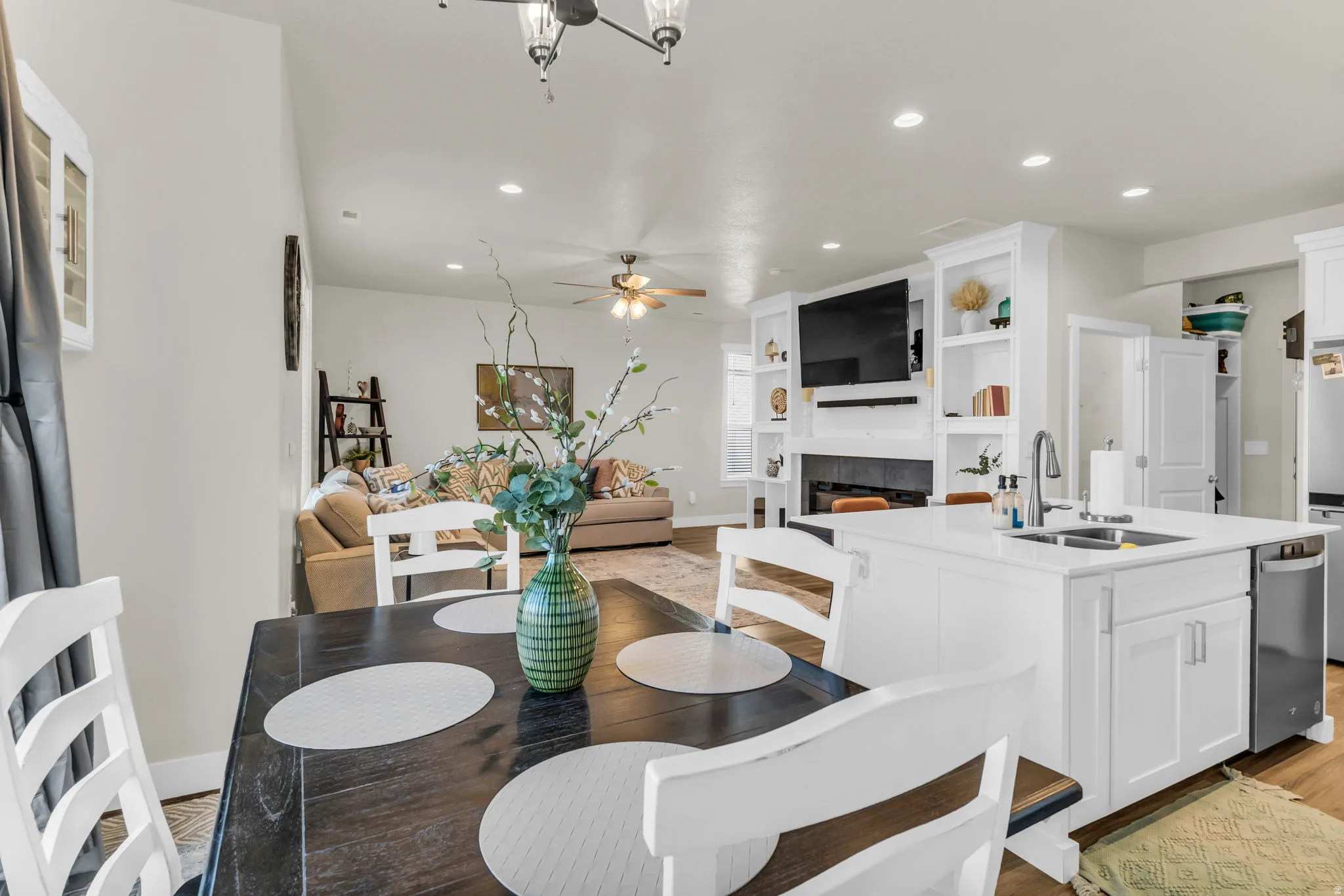 White kitchen island with an undermount stainless steel sink, integrated dishwasher, and white cabinetry