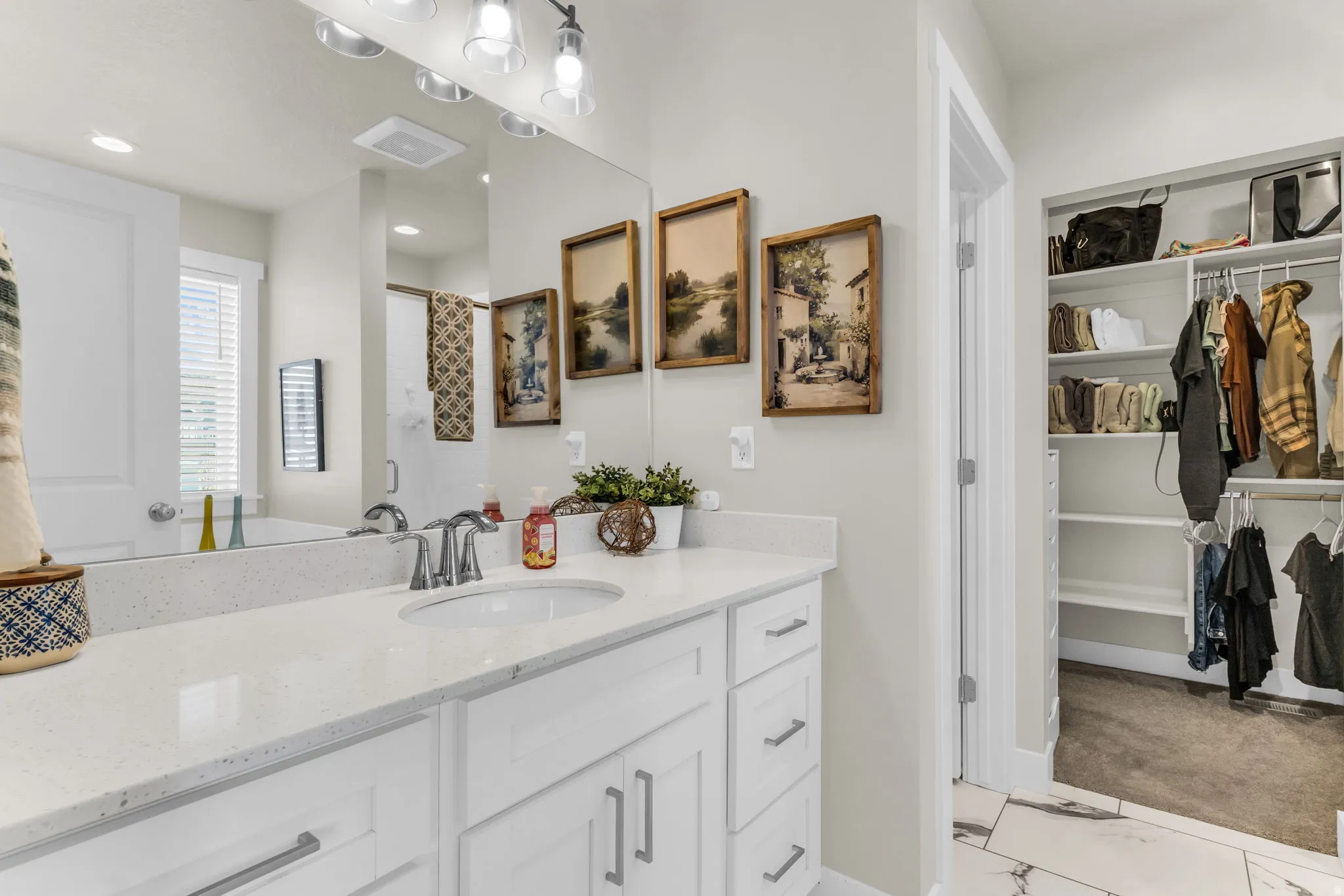 White vanity with integrated sink, speckled white countertop, and chrome faucet