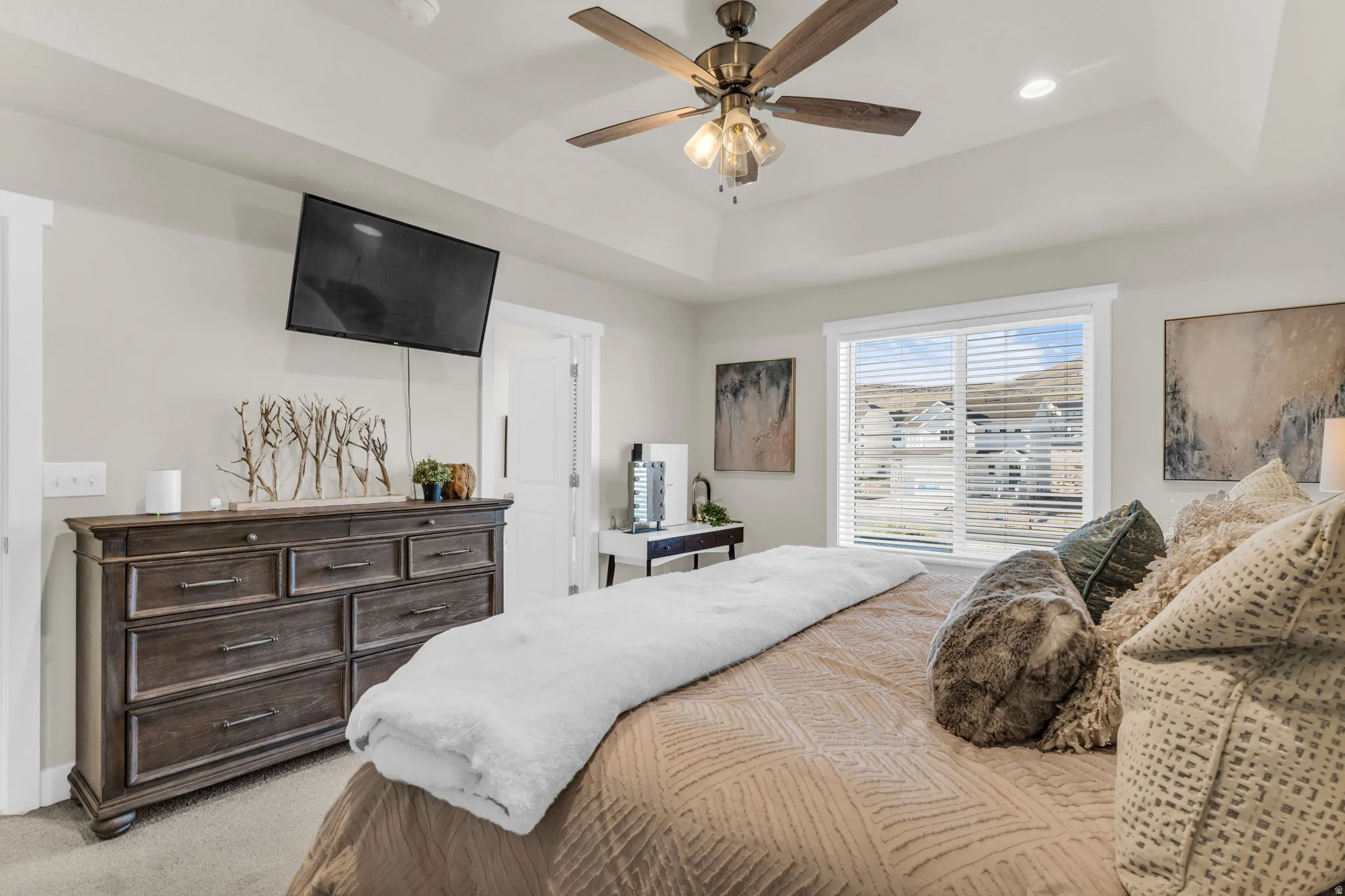Tray ceiling, ceiling fan with light fixture, recessed lighting, large window with blinds, and carpeted flooring