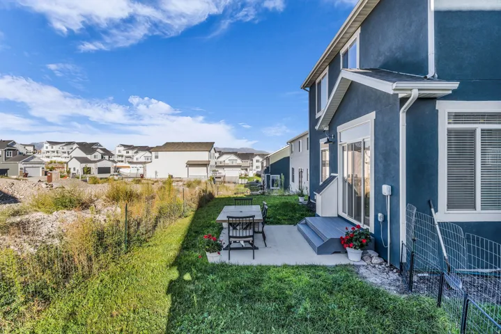 Blue stucco exterior with white trim, a sliding glass door, and a concrete patio