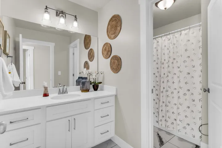 White vanity with extensive countertop space, under-mount sink, and contemporary hardware