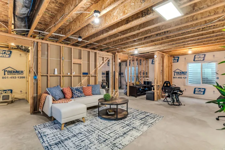 Unfinished basement  Five electrical outlets installed and overhead LED light, Exposed wood framing, concrete flooring, and an exposed ceiling structure