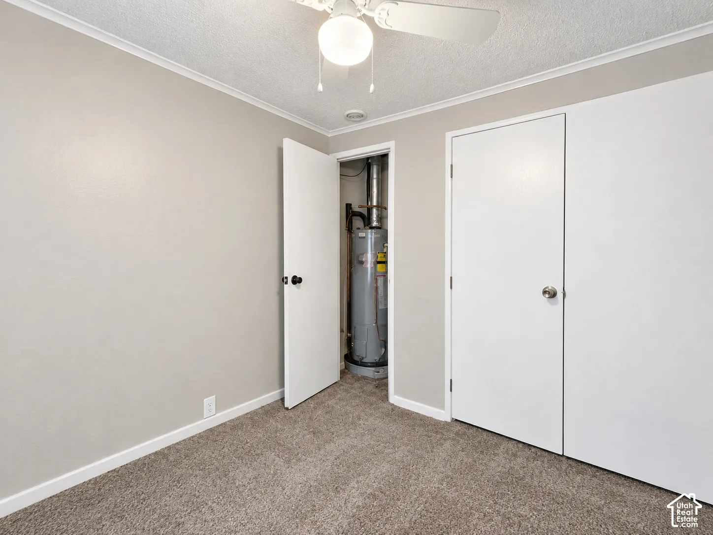 Textured carpeting, light-toned wall paint, white trim, and a ceiling fan with integrated lighting
