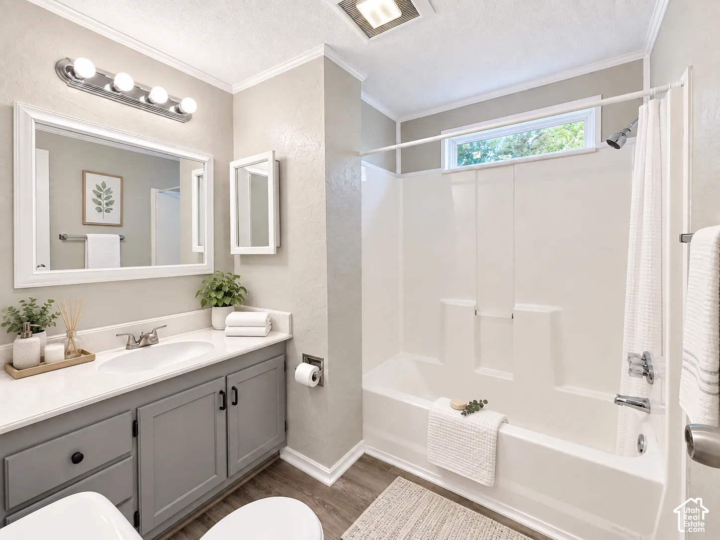 Vanity with gray cabinetry, white countertop, and integrated sink