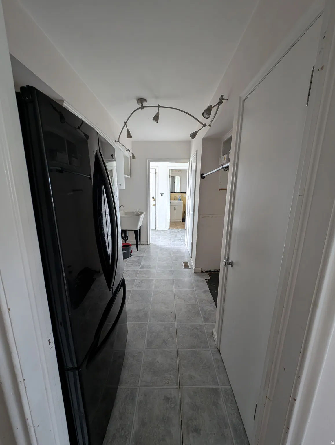 Track lighting fixture, tile flooring, and white interior doors