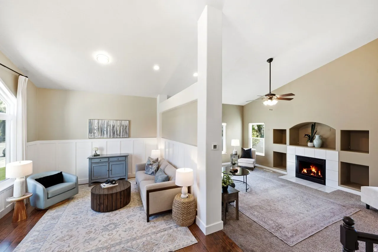 Vaulted ceiling, recessed lighting, wood-finish flooring, fireplace with tiled surround, and integrated shelving
