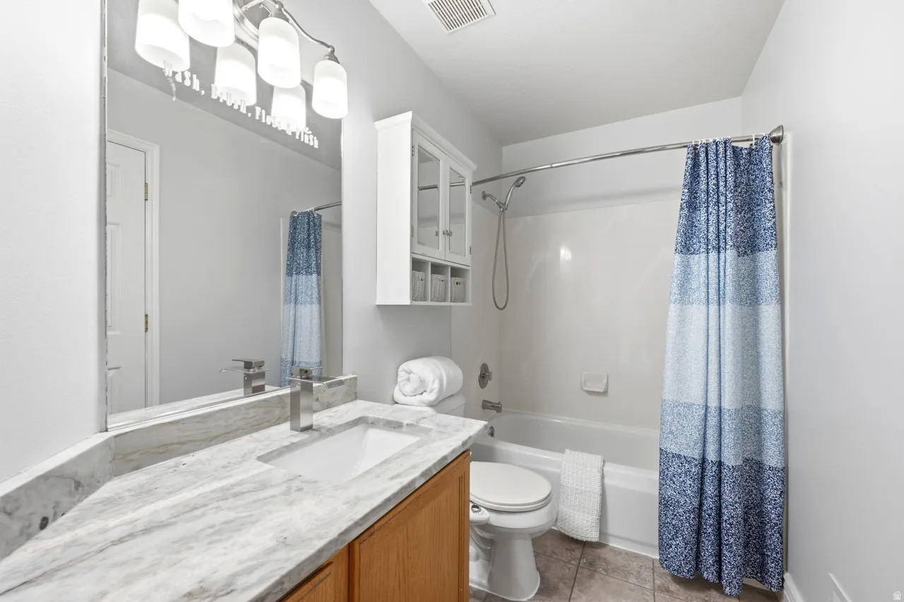 Vanity featuring a stone countertop, an integrated sink, and a modern single-handle faucet