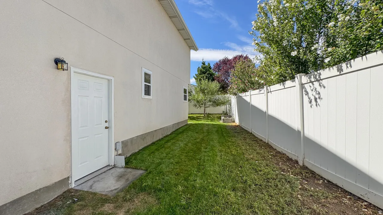 Exterior stucco siding with a white pedestrian door and black wall-mounted lighting