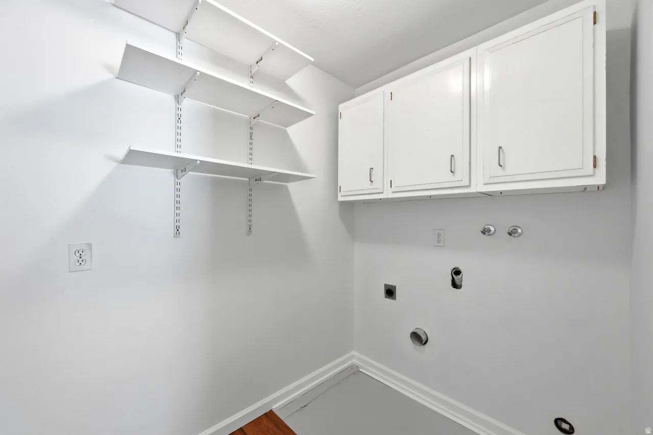 Adjustable wall-mounted shelving, built-in upper cabinetry, and laundry hookups