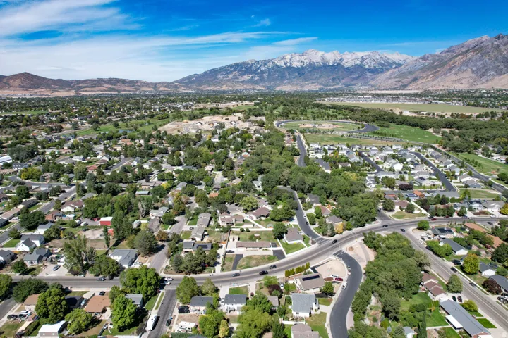 Expansive neighborhood with mature trees, established residential properties, prominent roadways, and distant snow-capped mountains