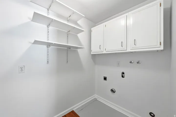 Adjustable wall-mounted shelving, built-in upper cabinetry, and laundry hookups