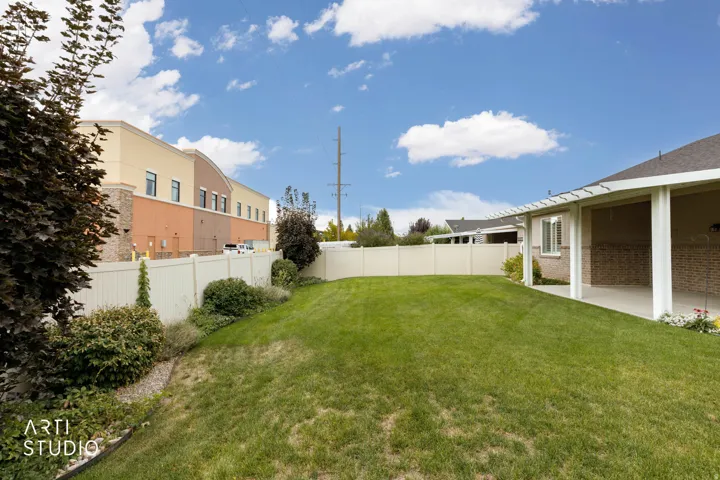 Expansive lawn with a white vinyl privacy fence and established shrubbery