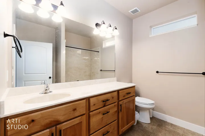 Double vanity with wood-finish cabinetry and light-toned countertops