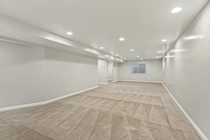 Expansive room featuring recessed lighting, a neutral color palette, and patterned carpeting