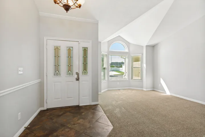 Entryway with tiled flooring, decorative glass door, and a multi-pane arched window