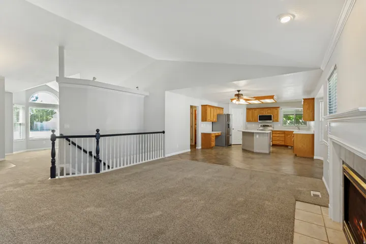 Vaulted ceilings, open concept kitchen, fireplace, wood cabinetry, and a bay window