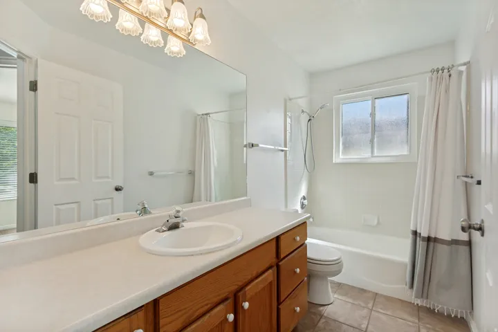 Vanity with wood-finish cabinetry, integrated sink, and laminate countertop