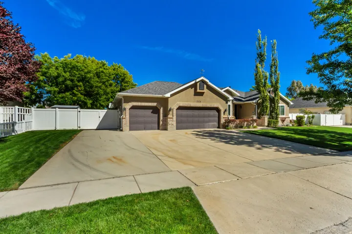 Stucco exterior with a shingled roof and brick accents