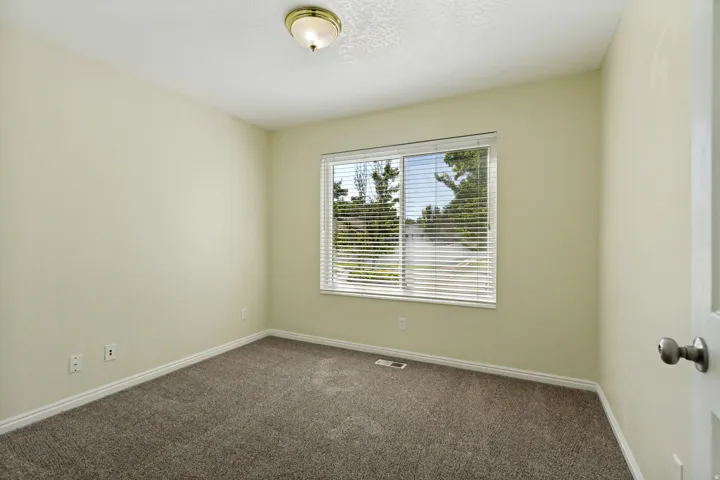 Carpeted flooring, neutral wall tones, window with blinds, and ceiling-mounted light fixture