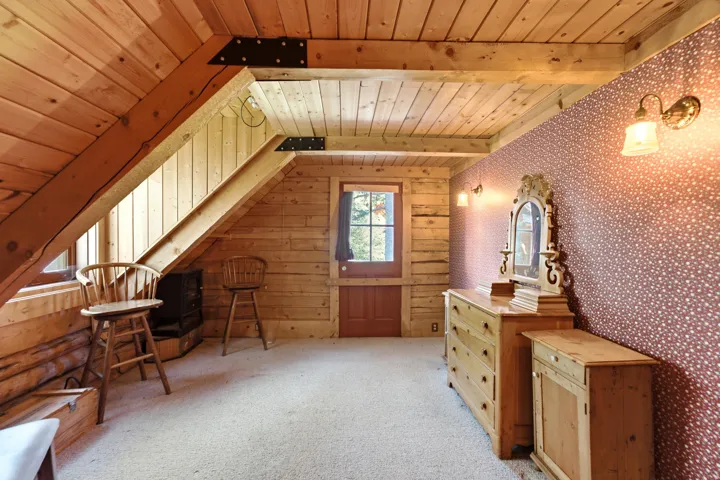 Sloped wood-paneled ceilings, exposed structural beams, and wood-paneled walls