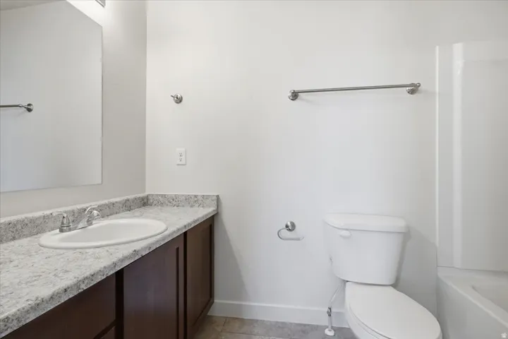 Vanity with a light-toned countertop, under-mount sink, and dark wood-finish cabinetry