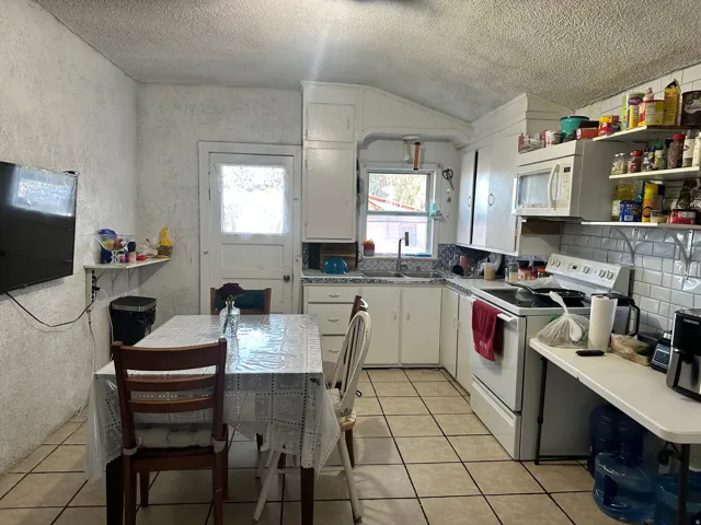 Kitchen featuring white cabinetry, tile flooring, white subway tile backsplash, and a built-in microwave