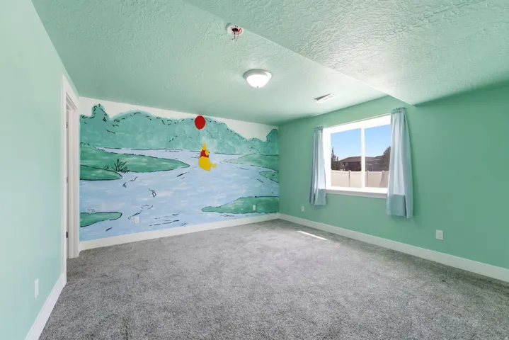 Wall-to-wall carpet flooring, light green painted walls, and a single window with a white frame