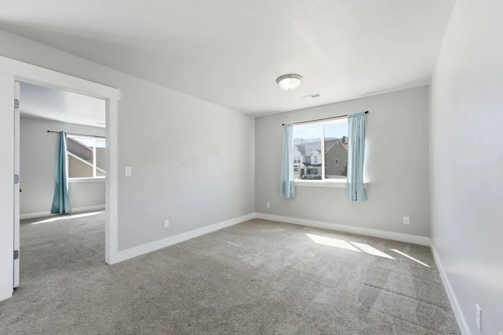 Spacious room with light gray wall paint and gray carpeting