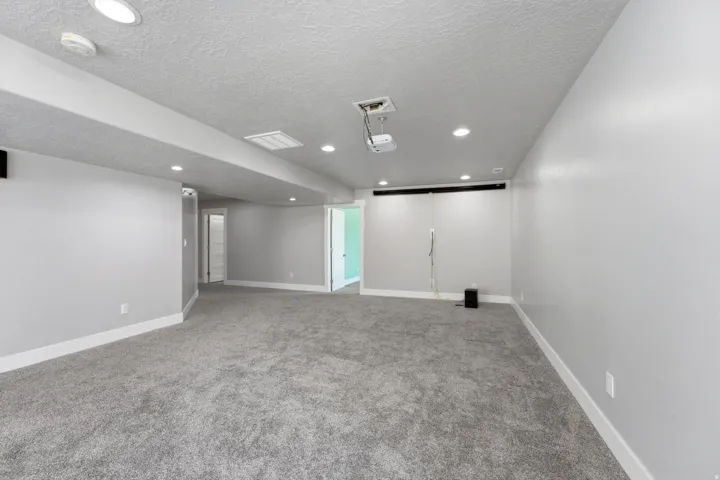 Spacious room with gray carpeting and light gray walls