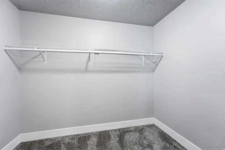 Built-in wire shelving, plush carpet flooring, and crisp white baseboards
