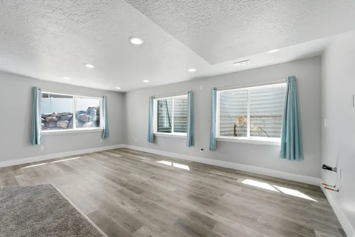 Recessed lighting illumination, light wood-finish flooring, white trim, and multiple windows