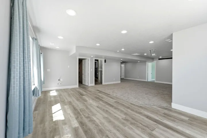 Recessed lighting, wood-finish flooring, two-panel interior doors, and a neutral color palette