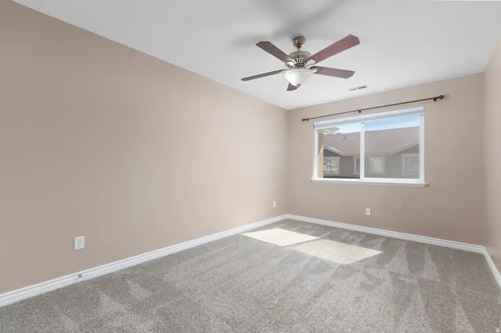 Neutral wall finishes, recessed window, ceiling fan with integrated lighting, and neutral carpeting