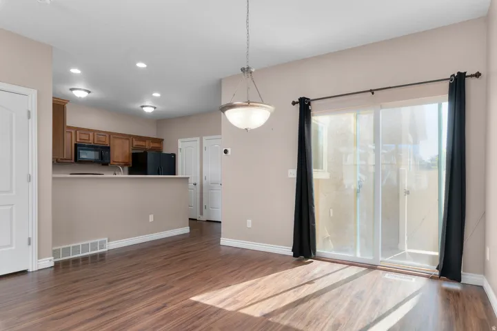 Wood-finish flooring, recessed lighting, and a contemporary chandelier
