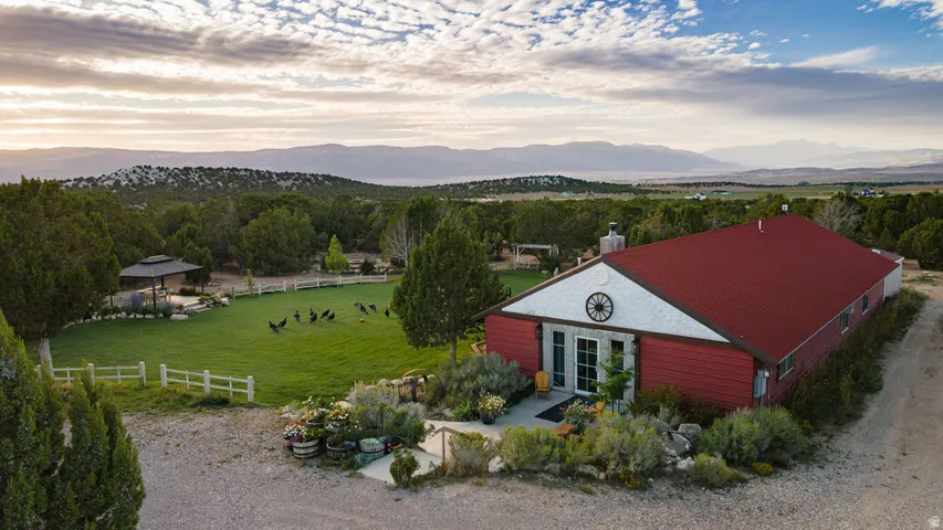 Barn-style residence featuring a red metal roof and stone facade