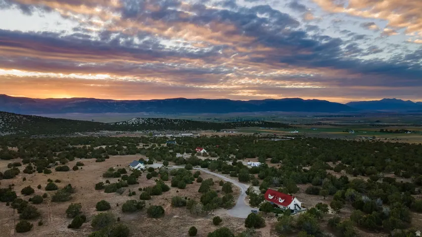 Expansive property with distant mountain ranges and scattered evergreen foliage